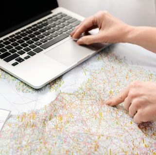 Unrecognizable woman using laptop computer on map 2025 03 18 17 52 47 utc