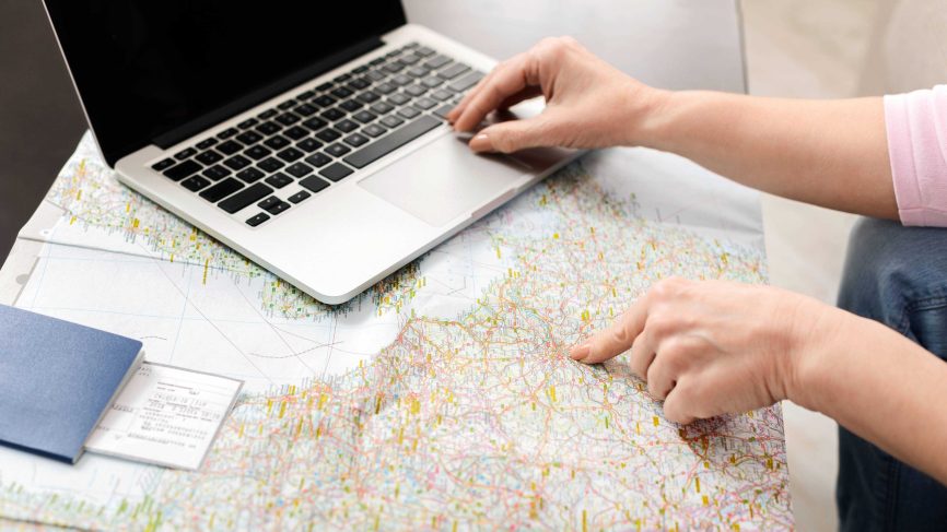 Unrecognizable woman using laptop computer on map 2025 03 18 17 52 47 utc 1